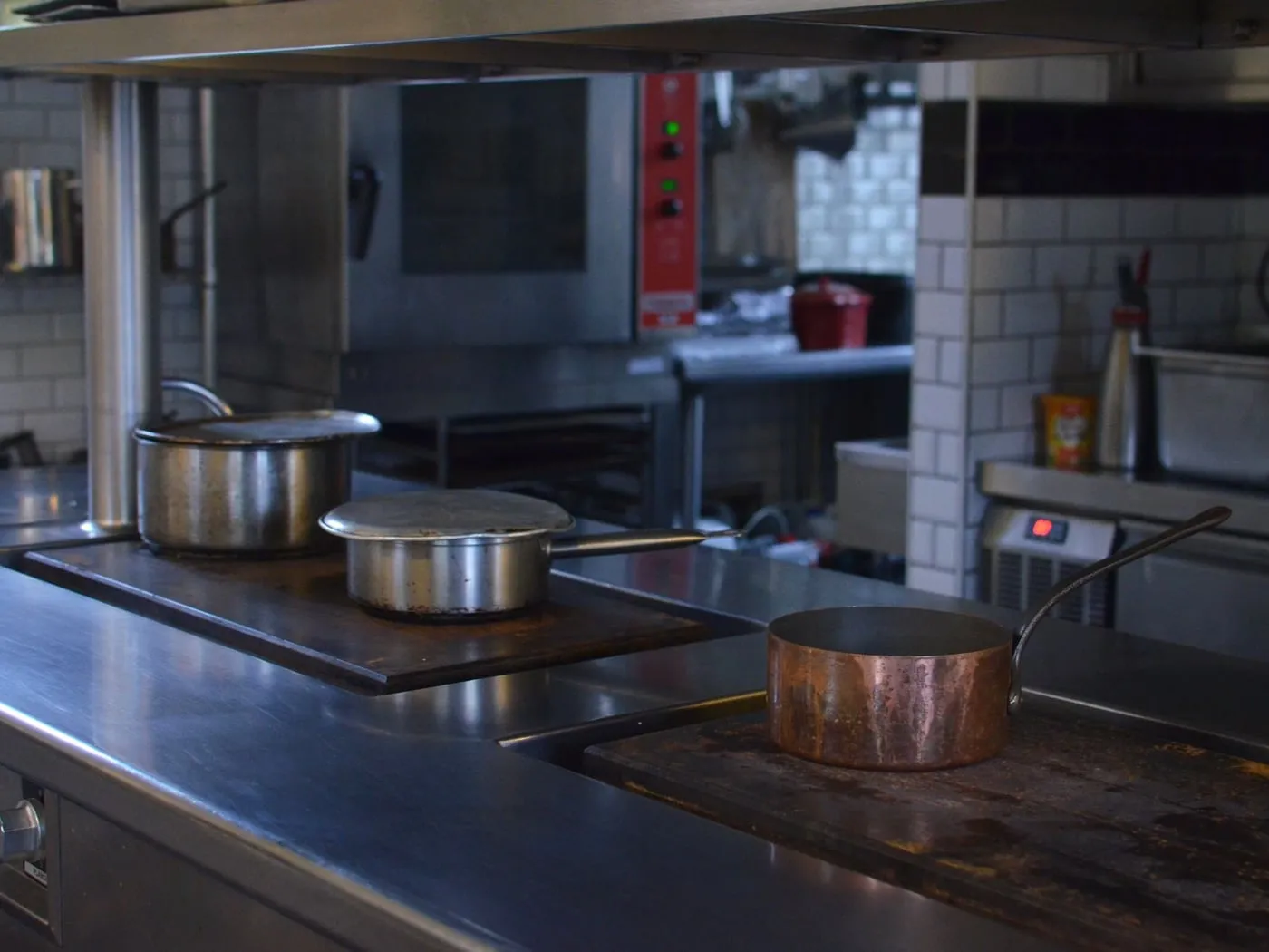 Cocina profesional con ollas al fuego sobre los fogones